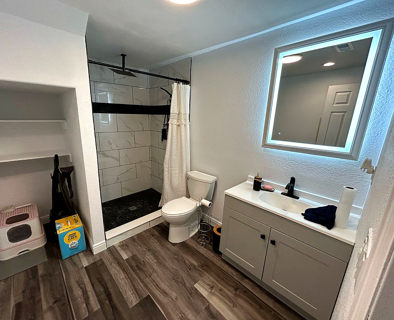 After — finished basement bathroom with shower and vanity